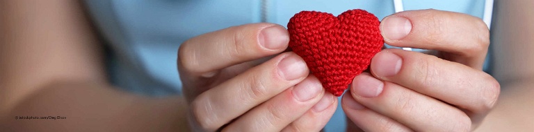 Kardiologin hält als Symbol für eine Herzklappenspende ein Herz aus Stoff in den Händen