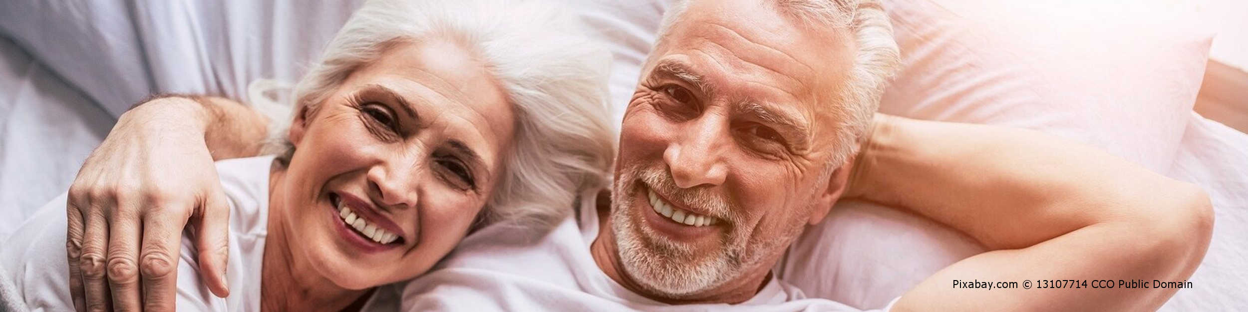 Älteres Paar ist nach Behandlung der vergrößerten Prostata im Bett wieder glücklich.